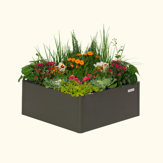 Urban Charcoal modern square raised garden bed with colorful flowers and plants on a white background.
