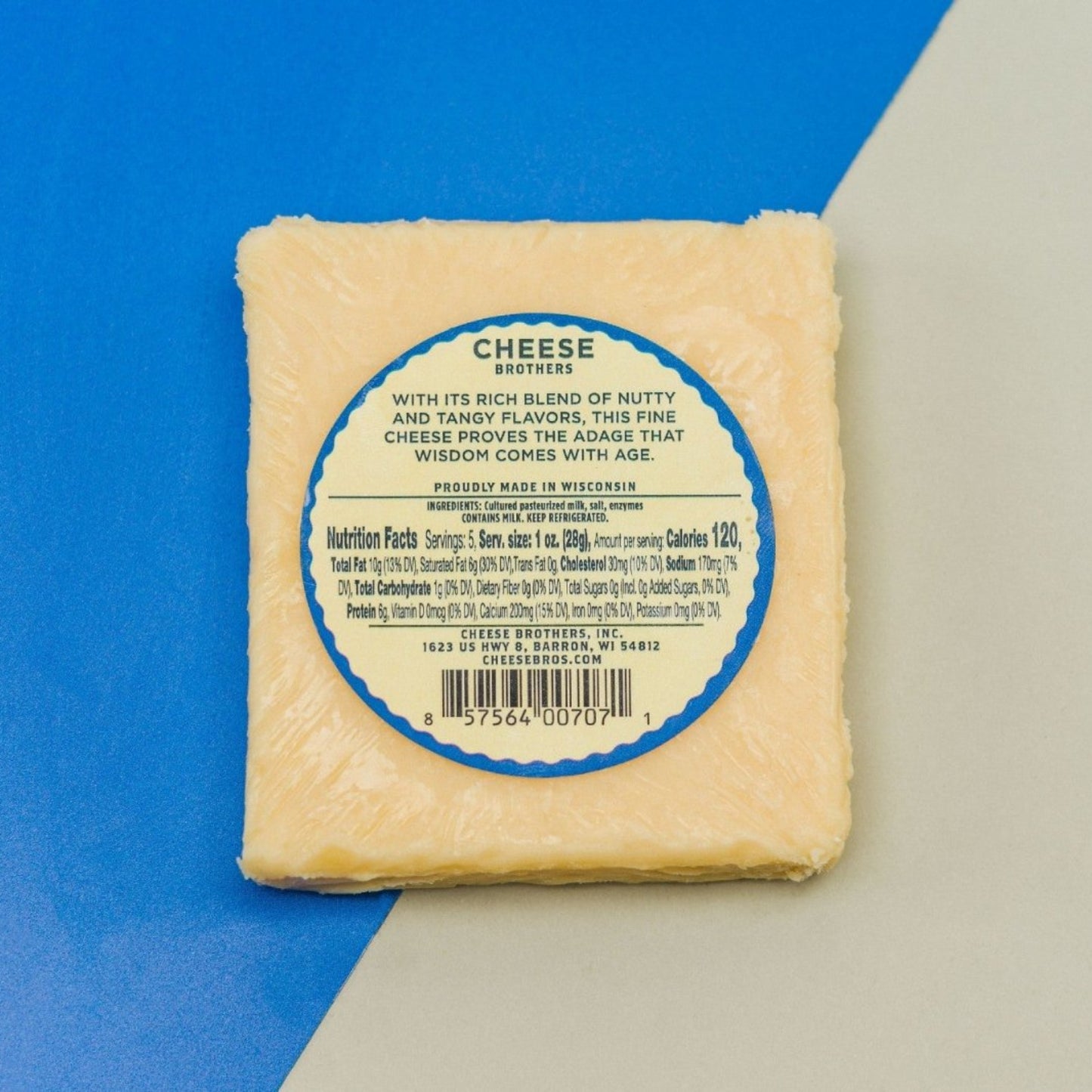 8 year aged cheddar block of cheese with nutrition and ingredients label presented on plain blue and white background