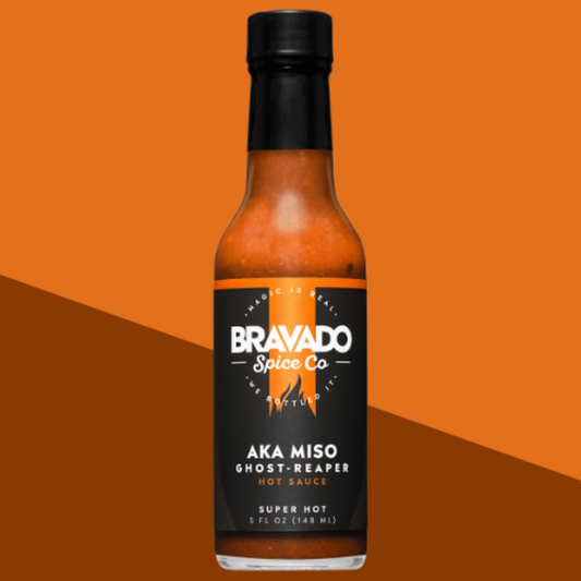 AKA Miso Ghost Reaper hot sauce bottle on an orange and brown gradient background