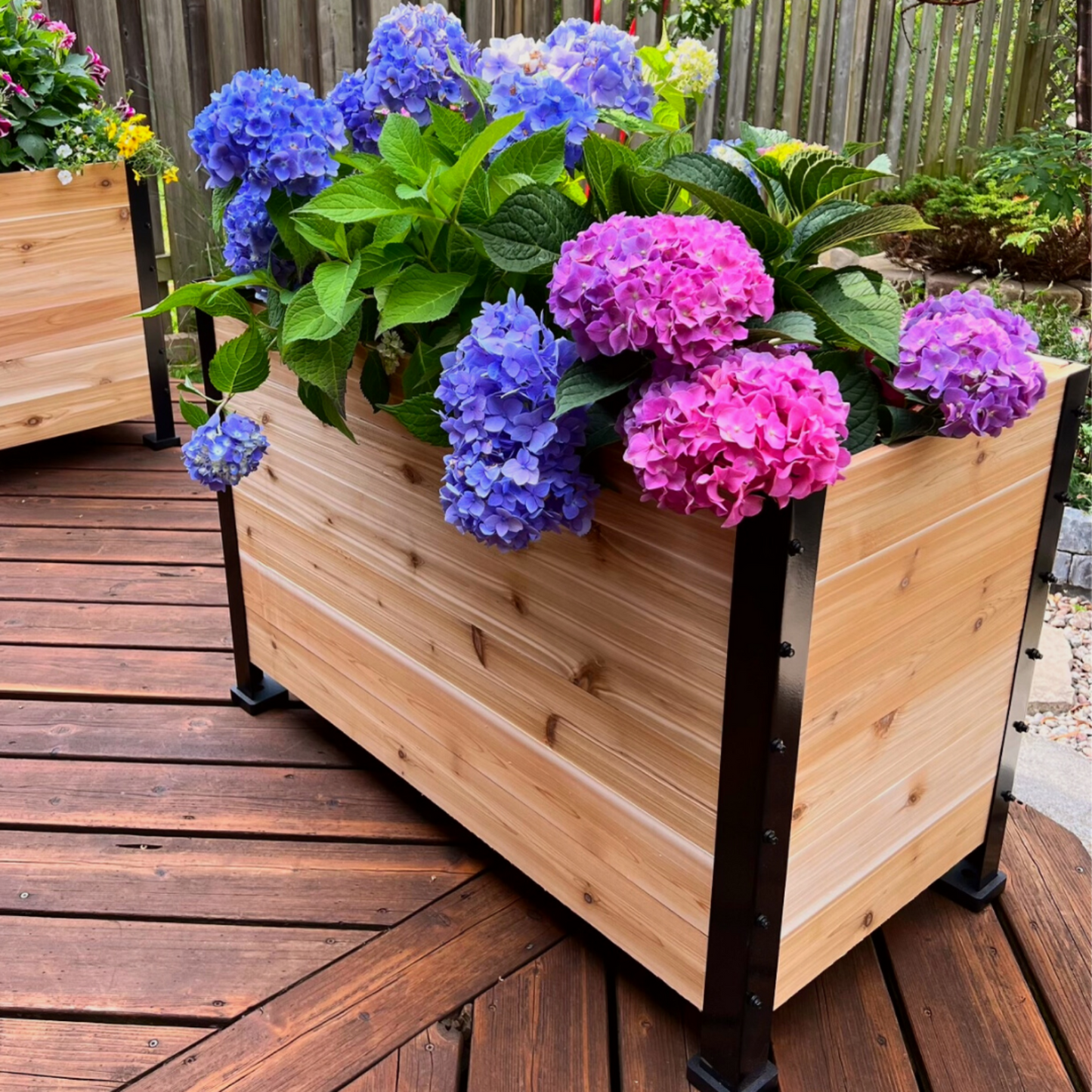 Cedar planter box with colorful flowers on a wooden deck