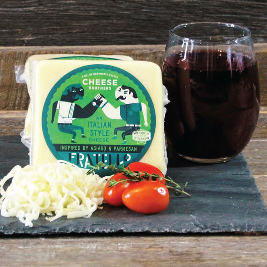 Block of Fratello cheese paired with wine and tomatoes on a serving platter