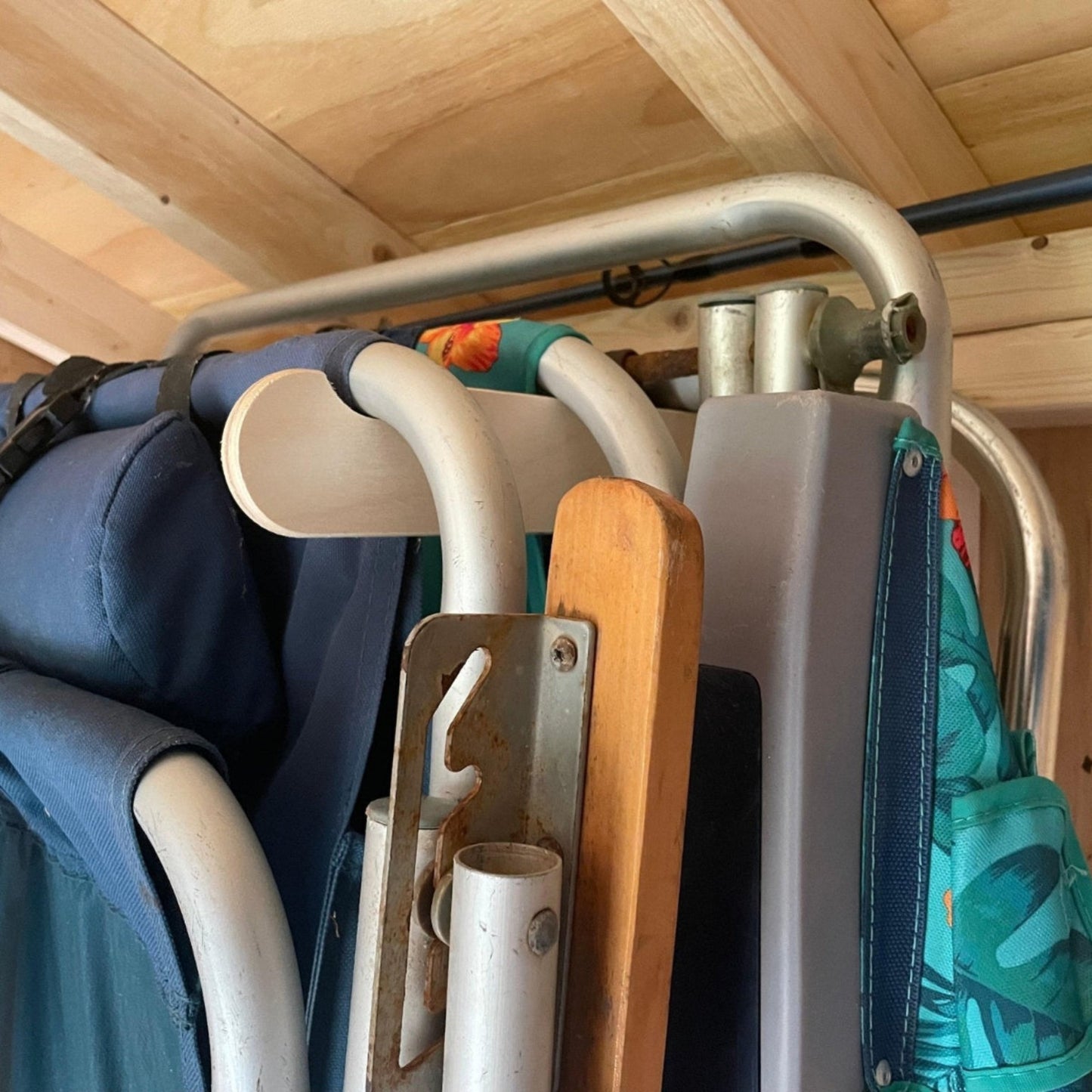 Close-up of a lawn chair organizer installed on a stud and lawn chairs in the rack.