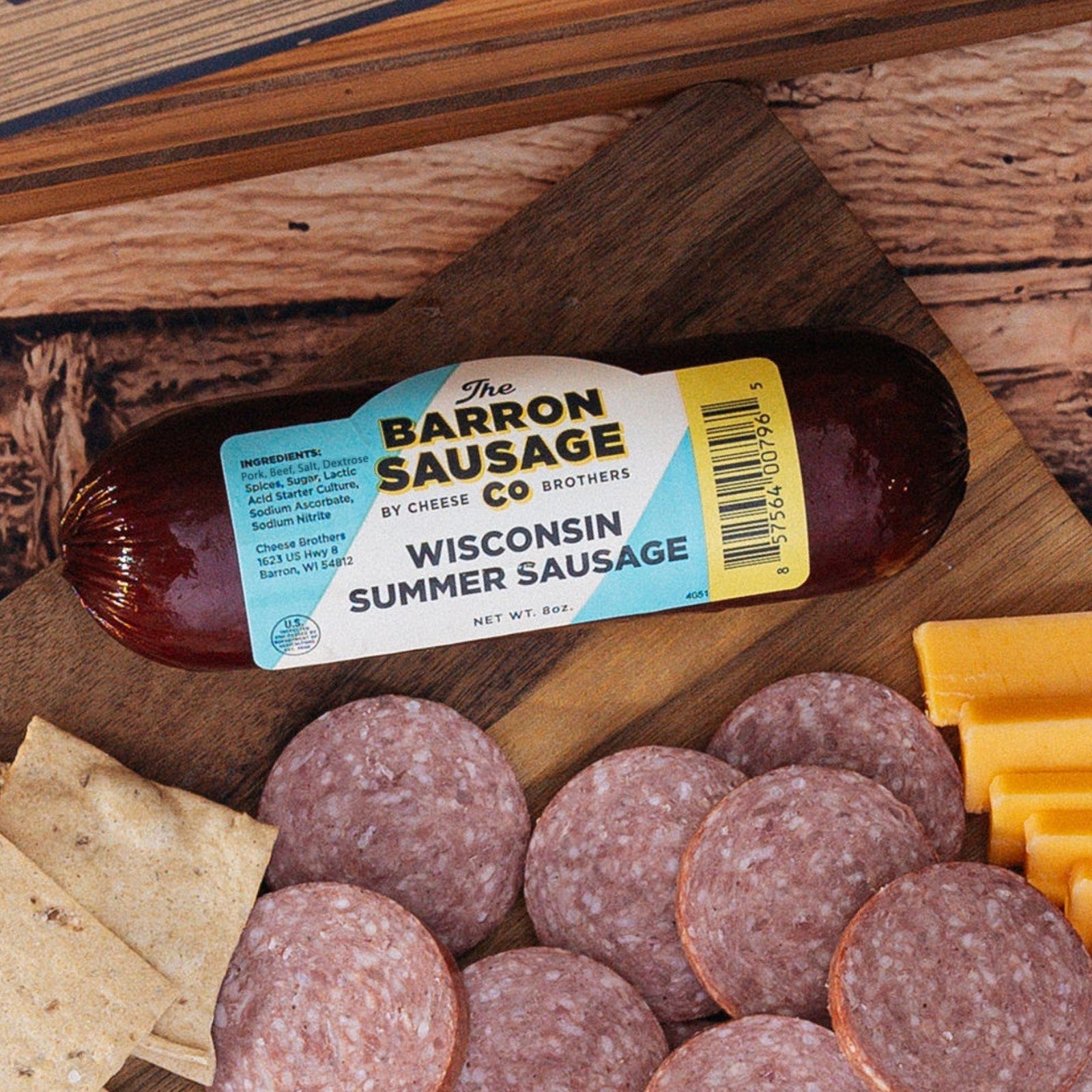 Summer Sausage packaging on a wooden board with summer sausage slices, cheese, and crackers
