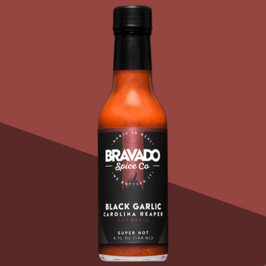 Bottle of Black Garlic Carolina Reaper hot sauce on a brown background