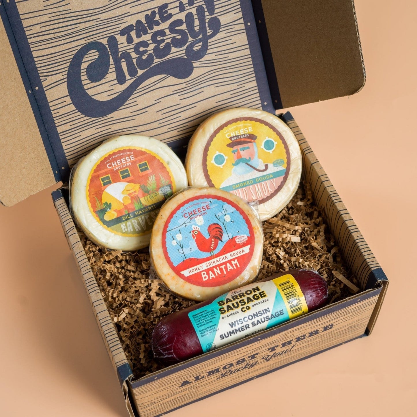 A variety of cheeses and a summer sausage packaged in a gift box