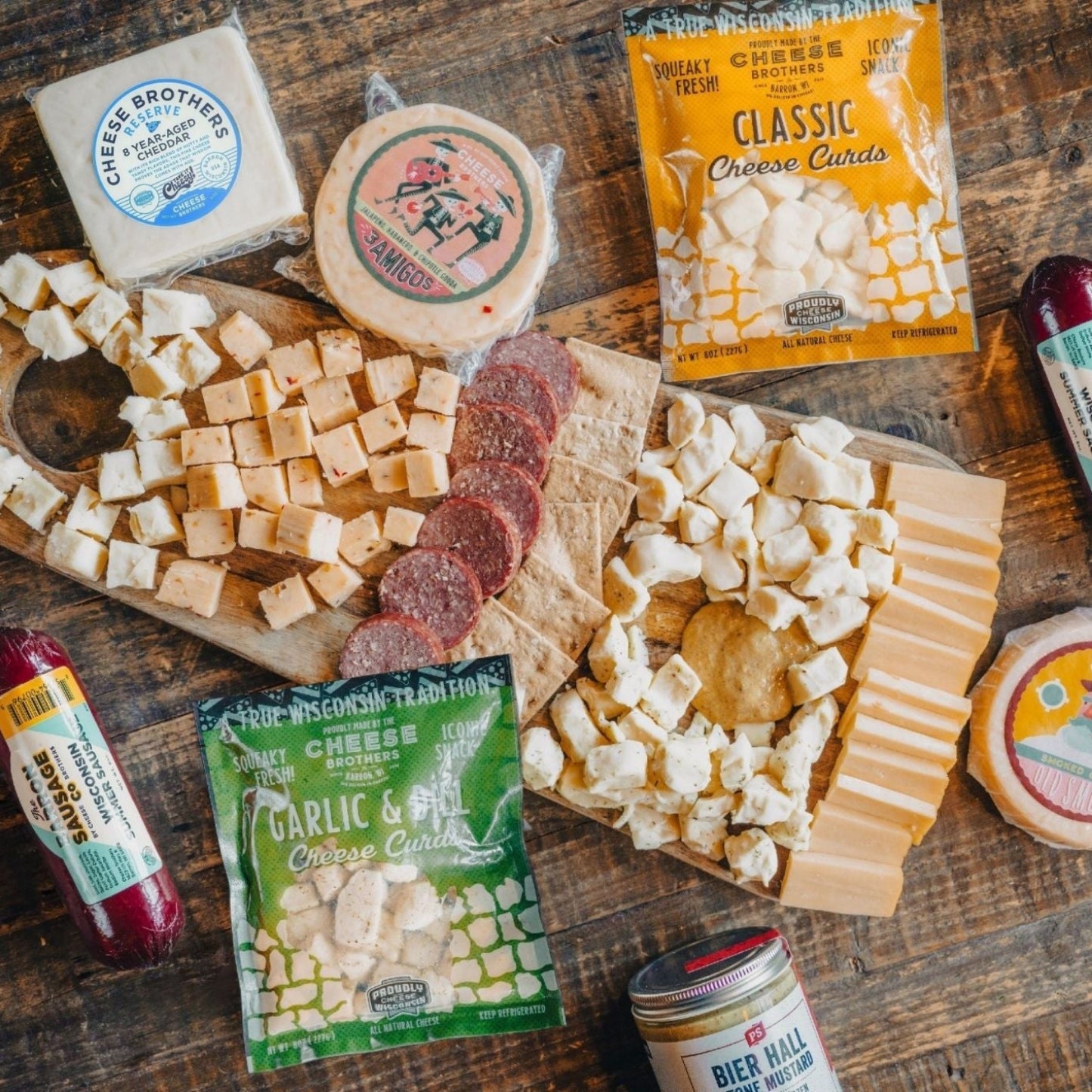 game day cheese gift box cheese curds and sliced cheese displayed on charcuterie board with summer sausage and crackers