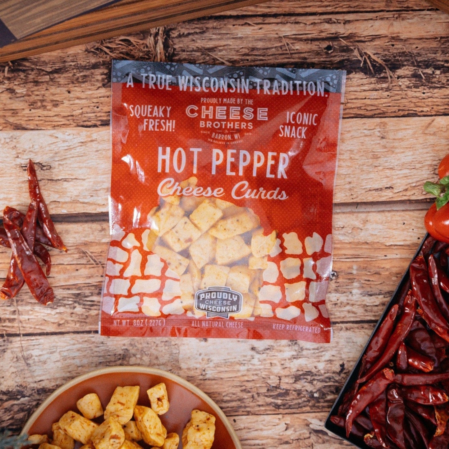 hot pepper cheese curds with dried hot peppers on wooden table