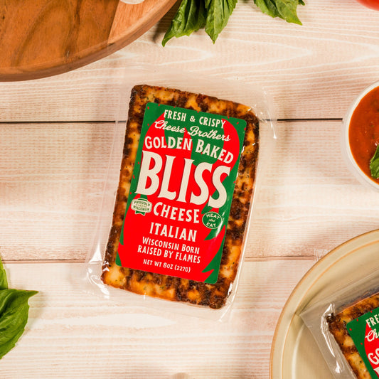 Italian Baked Bliss Cheese on white table with tomatoes and basil