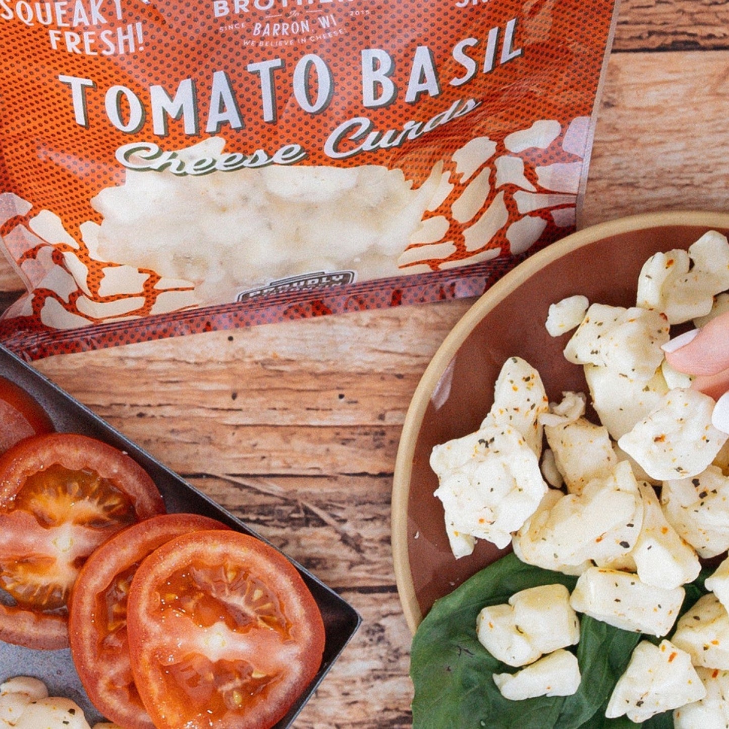 tomato basil cheese curds with sliced tomatoes on wooden table