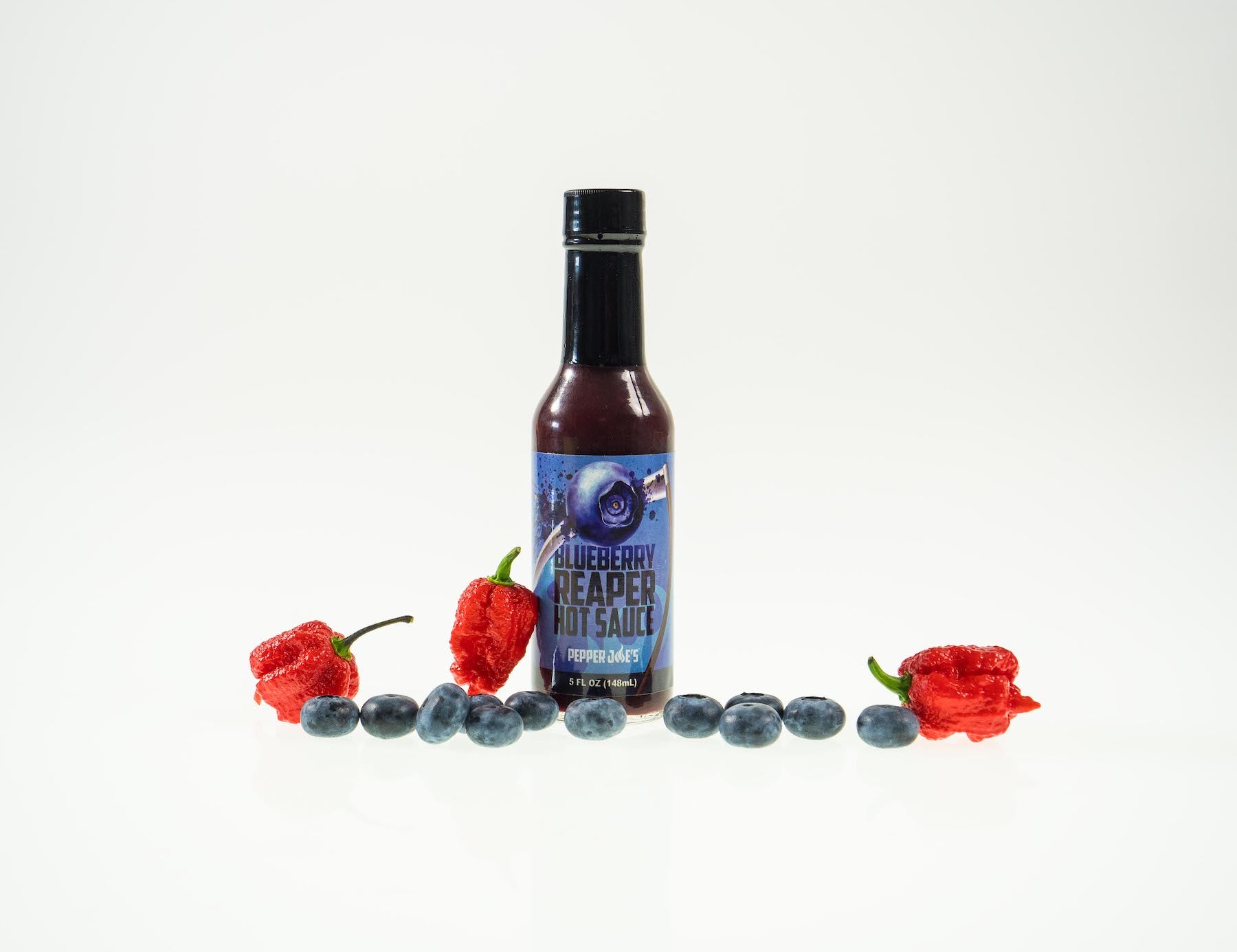 Pepper Joe's Carolina Reaper hot sauce gift set - Blueberry Reaper hot sauce bottle with blueberries around sauce