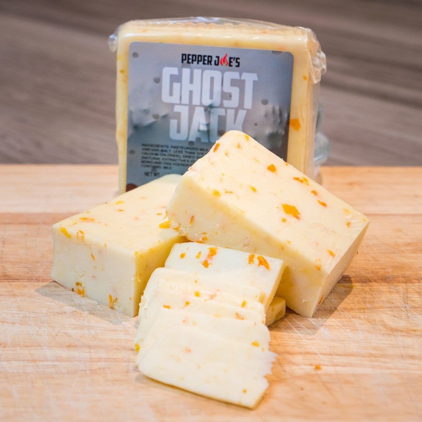 Pepper Joe's spicy Ghost Pepper Monterey Jack Cheese block on wood cutting board