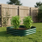 British green 11 inch raised garden bed with two young pepper plants in fenced backyard.