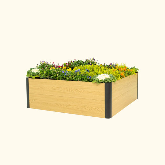 16 inch tall woodgrain 4 foot by 4 foot metal raised garden bed with flowers on a white background