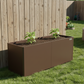 Image of umber brown raised garden bed with young pepper plants against a backyard fence
