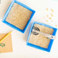 Two 5-inch hemp grow mats placed in blue seed starting trays with measuring spoons and corn seeds for planting