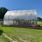 white shade cloth shown in use installed over outdoor greenhouse