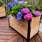 Cedar planter box with colorful flowers on a wooden deck