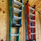 Two pairs of Step Ladder Organizers installed on an unfinished shed wall with step ladders hanging neatly.