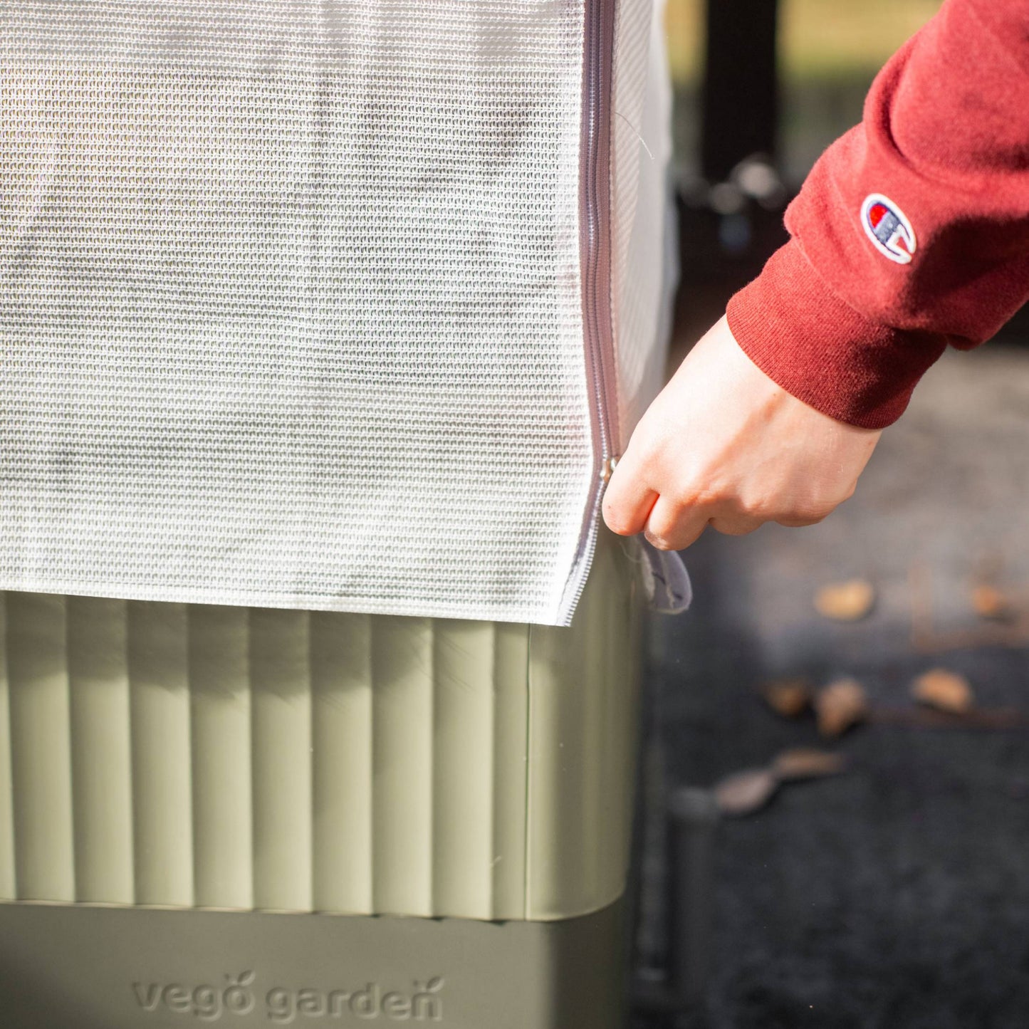 Close up of the zipper to close the EZCube Cover System 4-1 Trellis & Protection Kit installed on an EZCube Self-Watering Planter. 