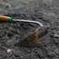 Close up of dirt on the EZ-Digger Korean triangle blade tool in use in a garden