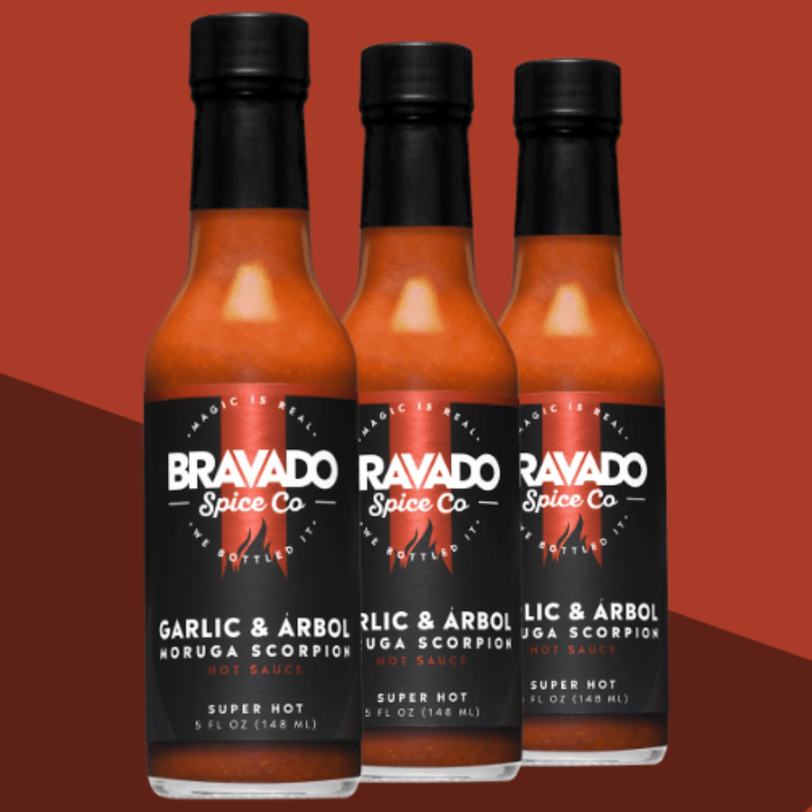 Three bottles of Garlic and Arbol Moruga Scorpion hot sauce on a red background