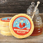 Honey Sriracha Gouda cheese wheels with a honey jar on a wooden surface