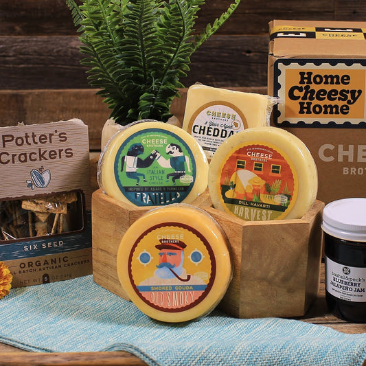 A gift basket containing various cheeses, organic crackers, and condiments