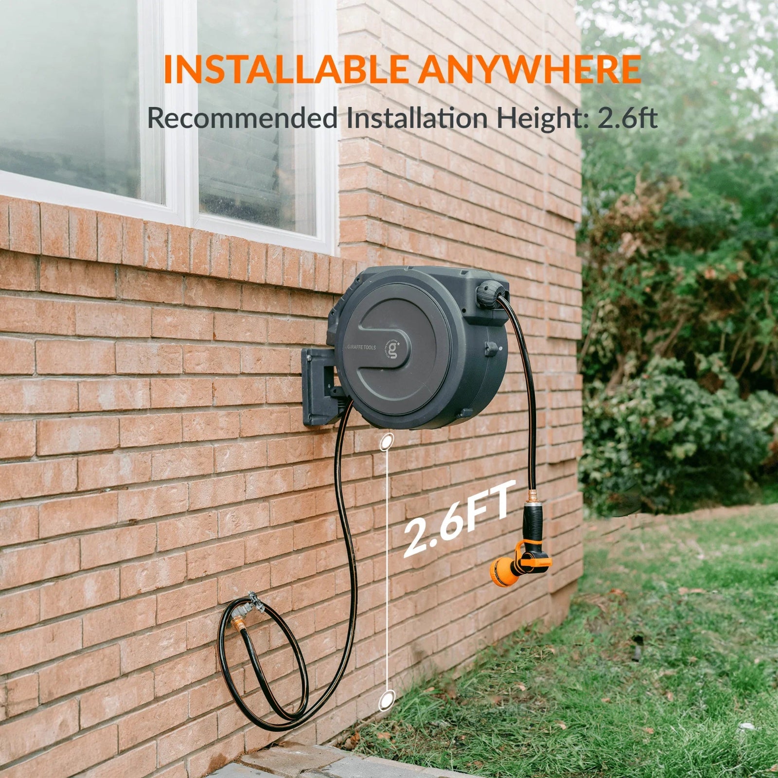 Retractable garden hose reel with leader hose installed against a brick wall, indicating installable anywhere with a recommended height of 2.6 feet from the ground.