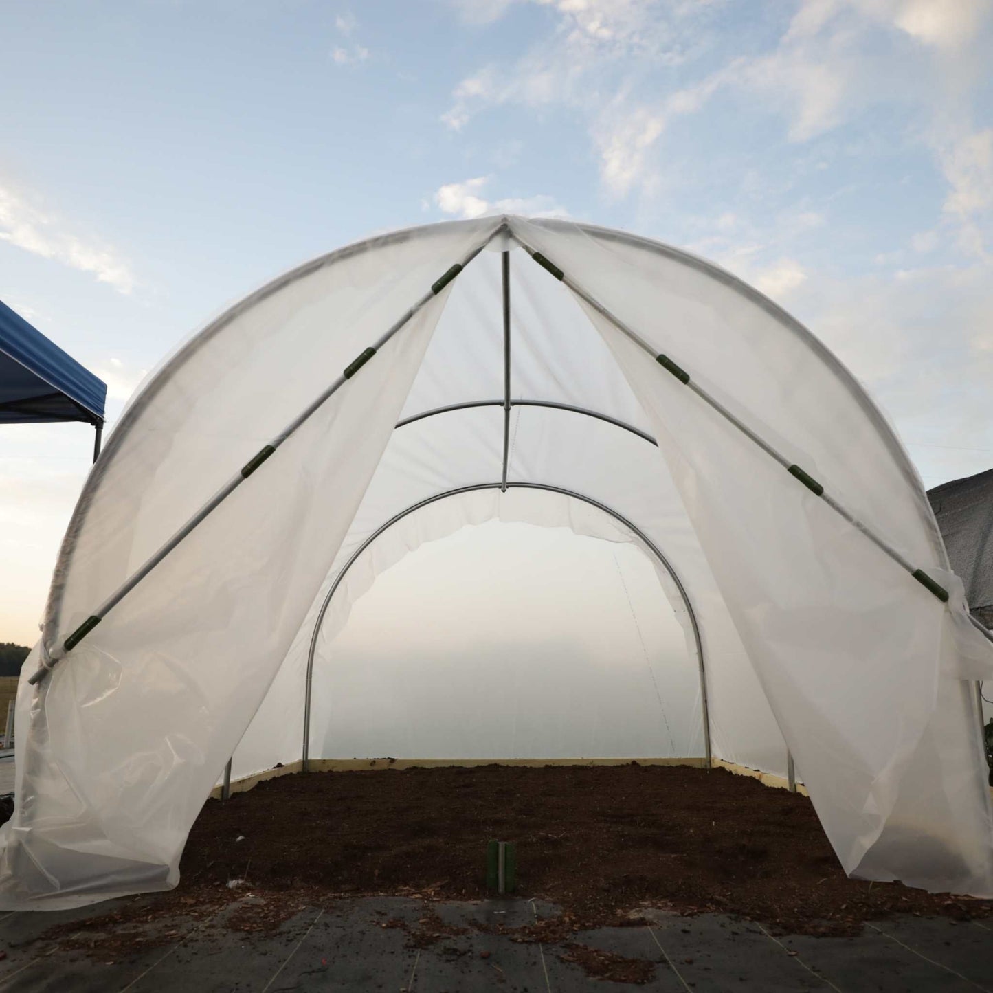 Scissor Door for Hobby Greenhouse kit installed in a backyard setting.