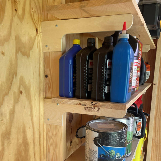 Stud-mounted brackets installed with boards for shelves holding multiple bottles and cans in a shed.