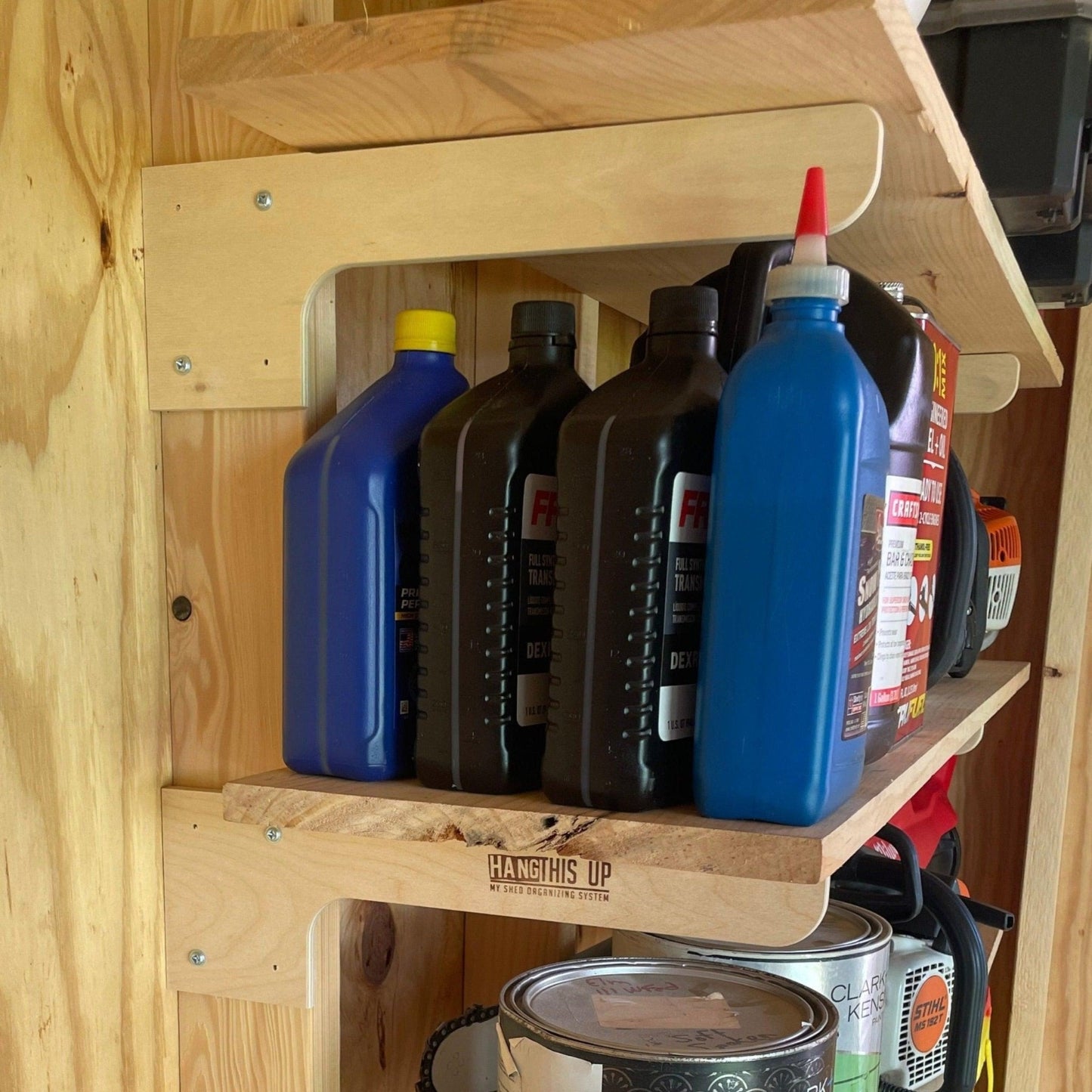 Stud-mounted brackets installed with boards for shelves holding multiple bottles and cans in a shed.