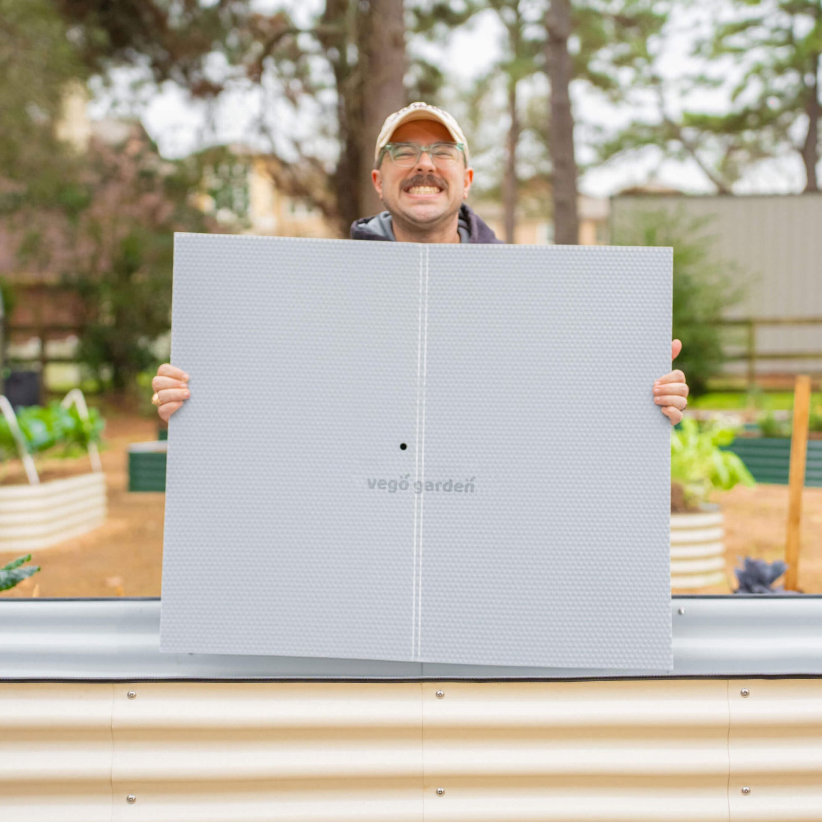 Person holding the top board soil partition of the Soil Saving Floor which goes into a 32 inch raised garden bed. 