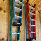 Two pairs of Step Ladder Organizers installed on an unfinished shed wall with step ladders hanging neatly.