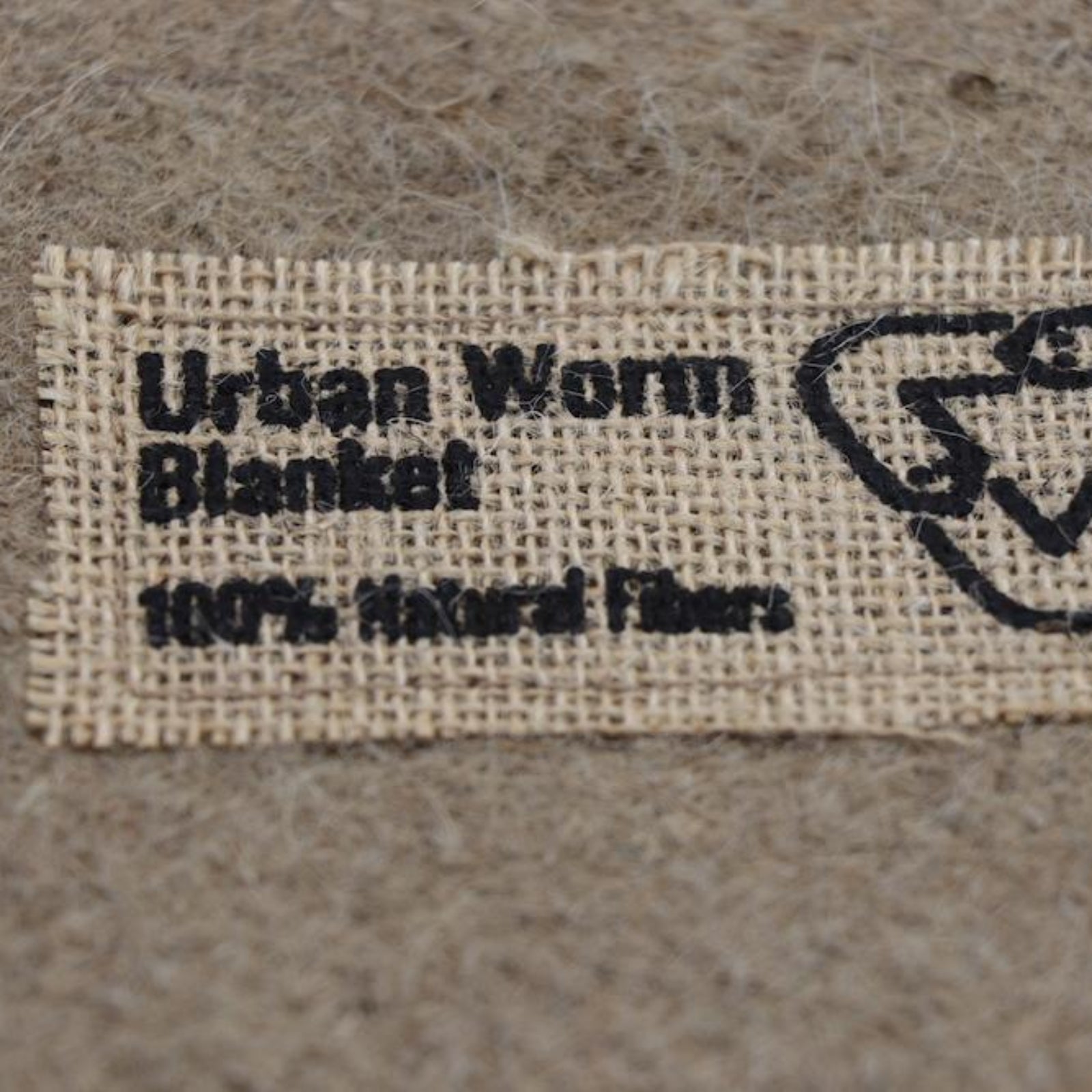 Close up of the label for 'Urban Worm Blanket' with '100% Natural Fibers' noted on the label.