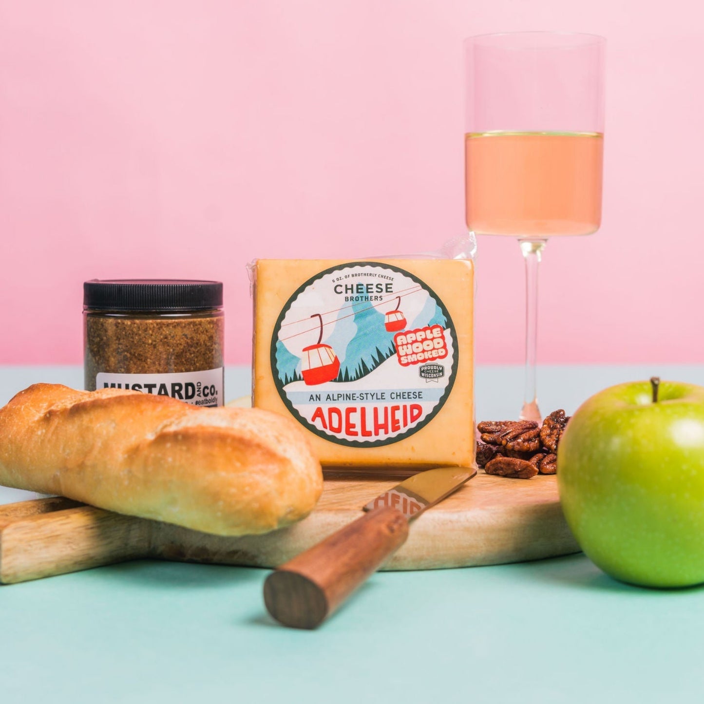 adelheid cheese block displayed with fruit, wine and bread on charcuterie board