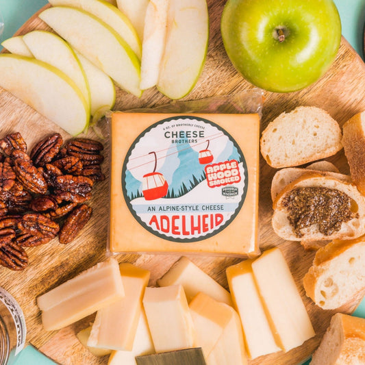 overhead view of adelheid cheese displayed on charcuterie board with fruits and nuts