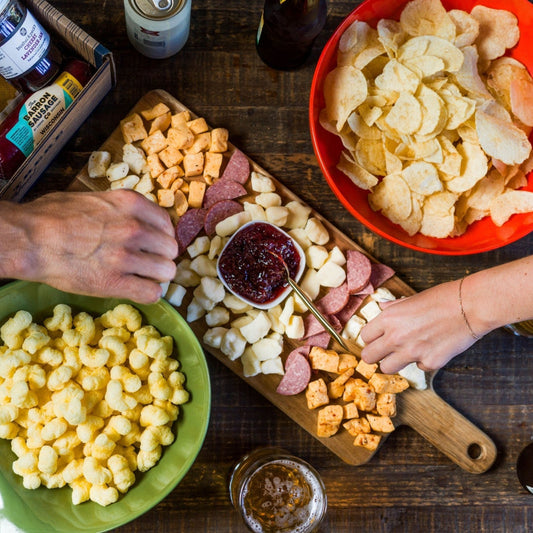 Char-CURD-erie Box with Wisconsin cheese curds, summer sausage, blueberry jalapeño jam, and snacks served on a wooden board.