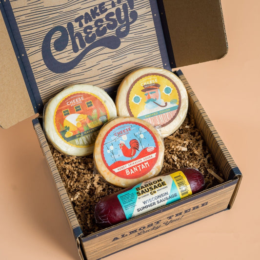 A variety of cheeses and a summer sausage packaged in a gift box 