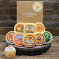 An assortment of cheese blocks presented on a wooden surface including various flavors like smoked gouda, fratello, dill havarti with decorative elements like a birthday cupcake and sprinkles