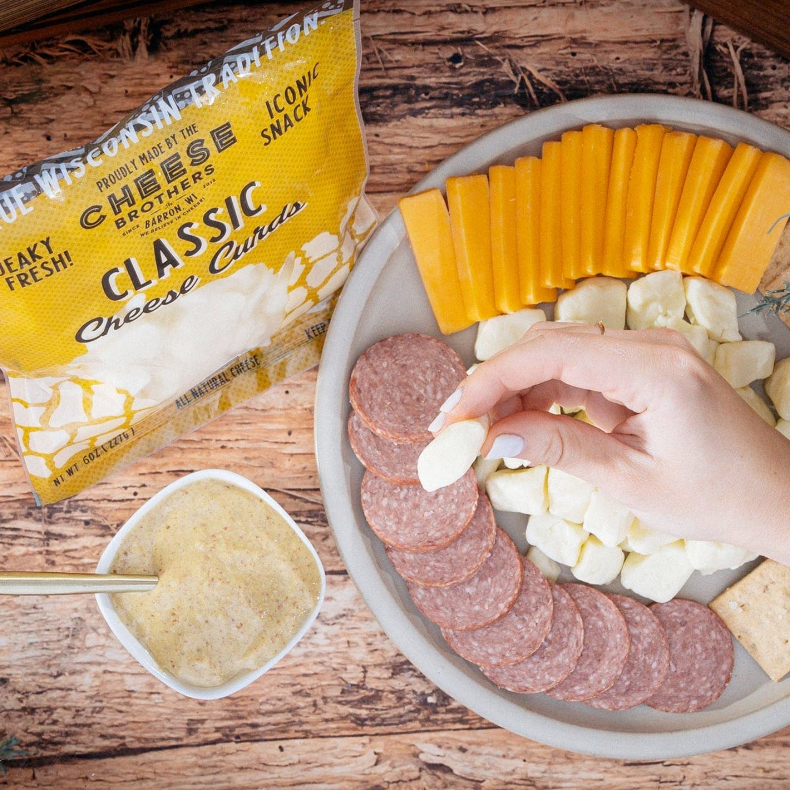Classic Wisconsin cheese curds and cheese slices on a plate with salami and mozzarella
