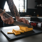 cutting pepper joes carolina reaper cheddar next to reaper summer sausage on slate cutting board