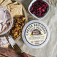 Cranberry Walnut cheese spread with crackers and berries on a wooden board.