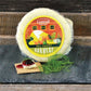  Dill Havarti Cheese: round wheel of dill Havarti cheese on plate with rustic background