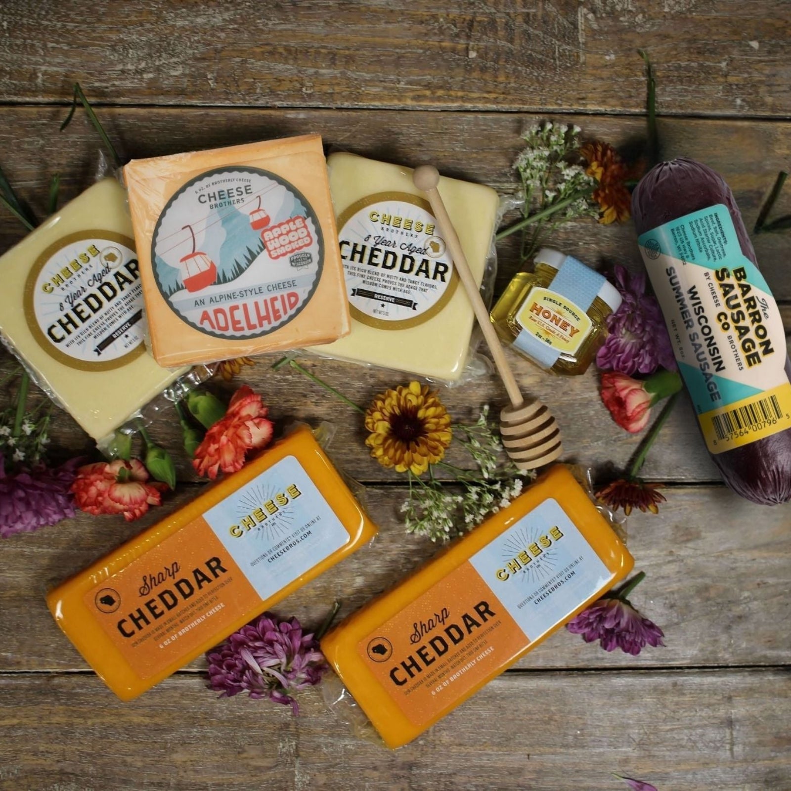 Feel cheddar soon gift box cheeses displayed amongst flowers on wooden tray