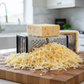 Pepper Joe's spicy Ghost Pepper Jack cheese partially grated on wood cutting board
