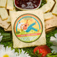 Green onion cheddar cheese block presented on a serving platter with sliced cheese, crackers, jelly, and green onion