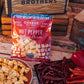Bag of hot pepper cheese curds with cheese curds and red peppers on a wooden surface