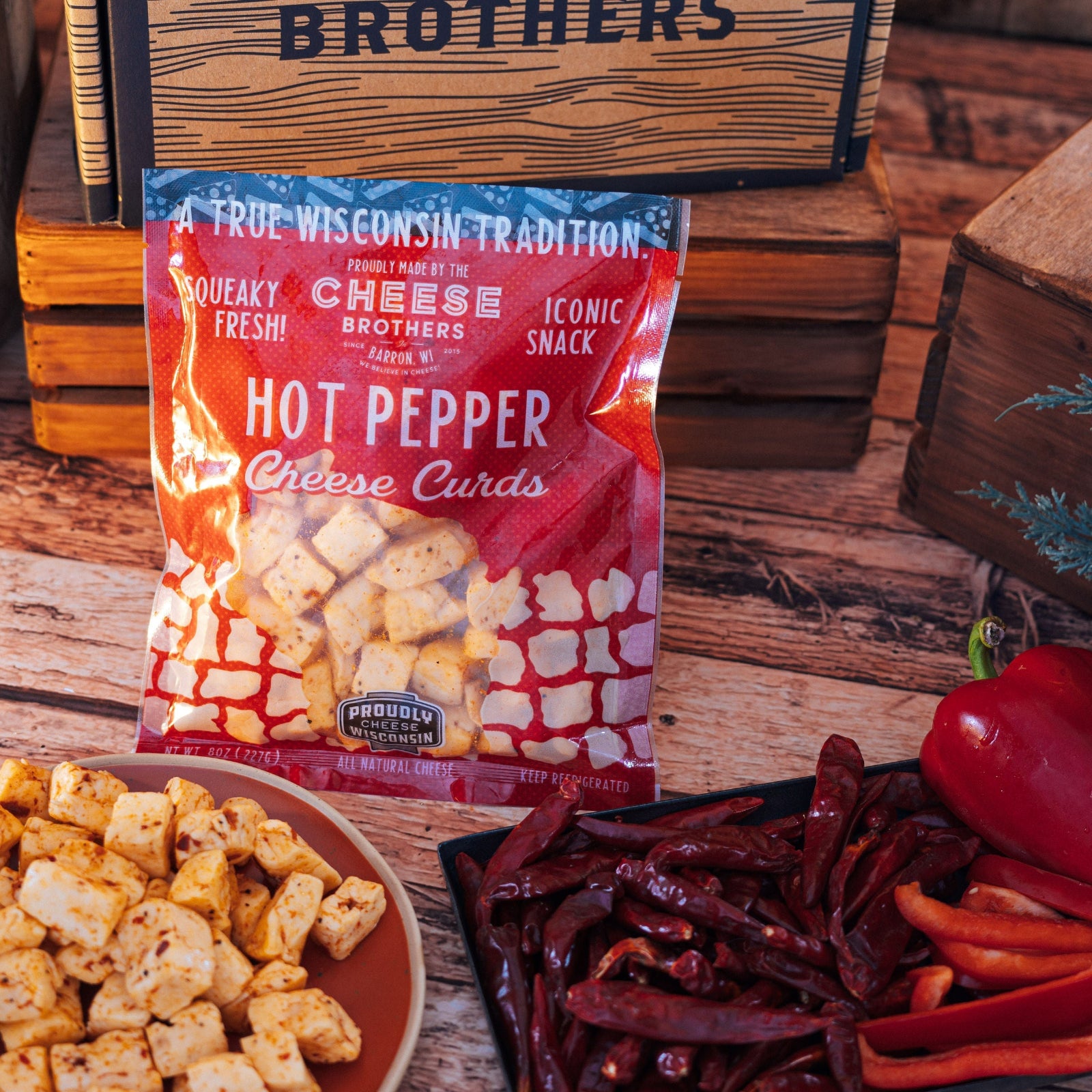 Bag of hot pepper cheese curds with cheese curds and red peppers on a wooden surface