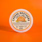Container of jalapeno pepper cheese spread on orange background