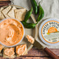 Jalapeno Pepper Cheese Spread on top of crackers with jalapenos on a wood table